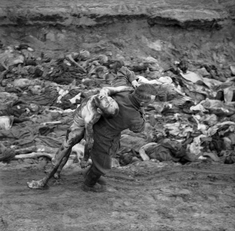 Бывший охранник СС переносит труп узника концлагеря Берген-Бельзен для погребения в общей могиле