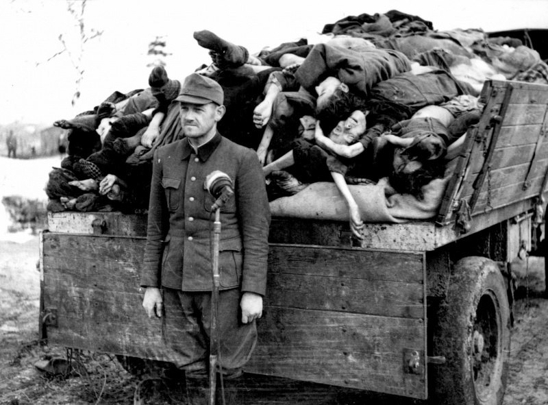 Бывший оберштурмфюрер СС Франц Хёсслер у микрофона перед грузовиком с телами узников концлагеря Берген-Бельзен.