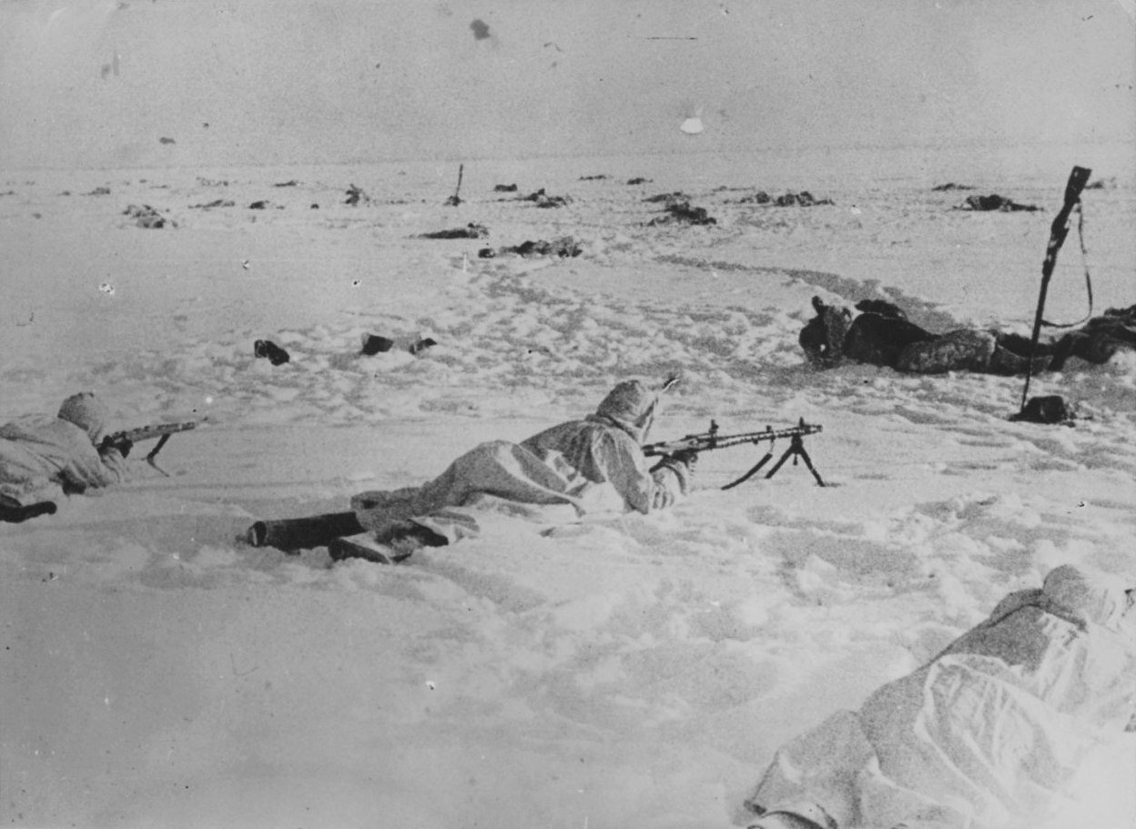 Стрелки вермахта и пулеметчик с MG43 на позиции у тел мёртвых советских бойцов. 1942 г.
