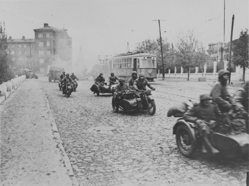Немецкие мотоциклисты и грузовики на проспекте Ильича в захваченном Мариуполе.