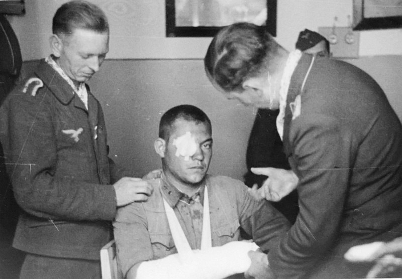 Раненый советский летчик и бойцы Люфтваффе. 1941 г.