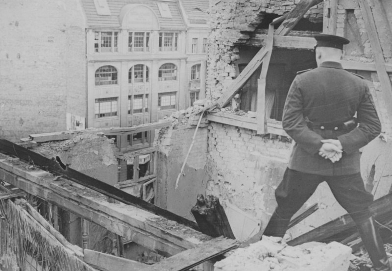 Советский офицер осматривает руины дома в Берлине.