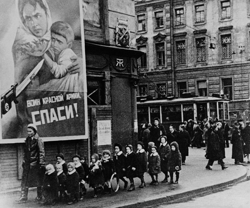 Дети проходят у плаката «Воин Красной армии спаси!» на стене дома в Ленинграде